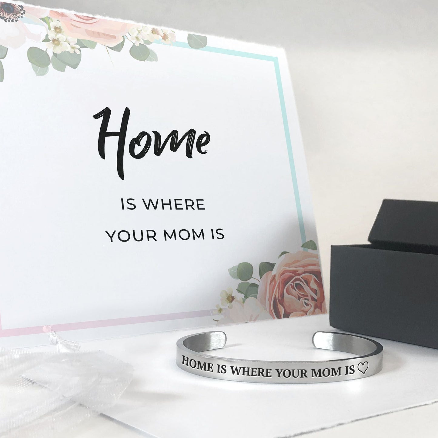 Home is where your mom is bracelet in silver with a gift box, bag, and card in the background