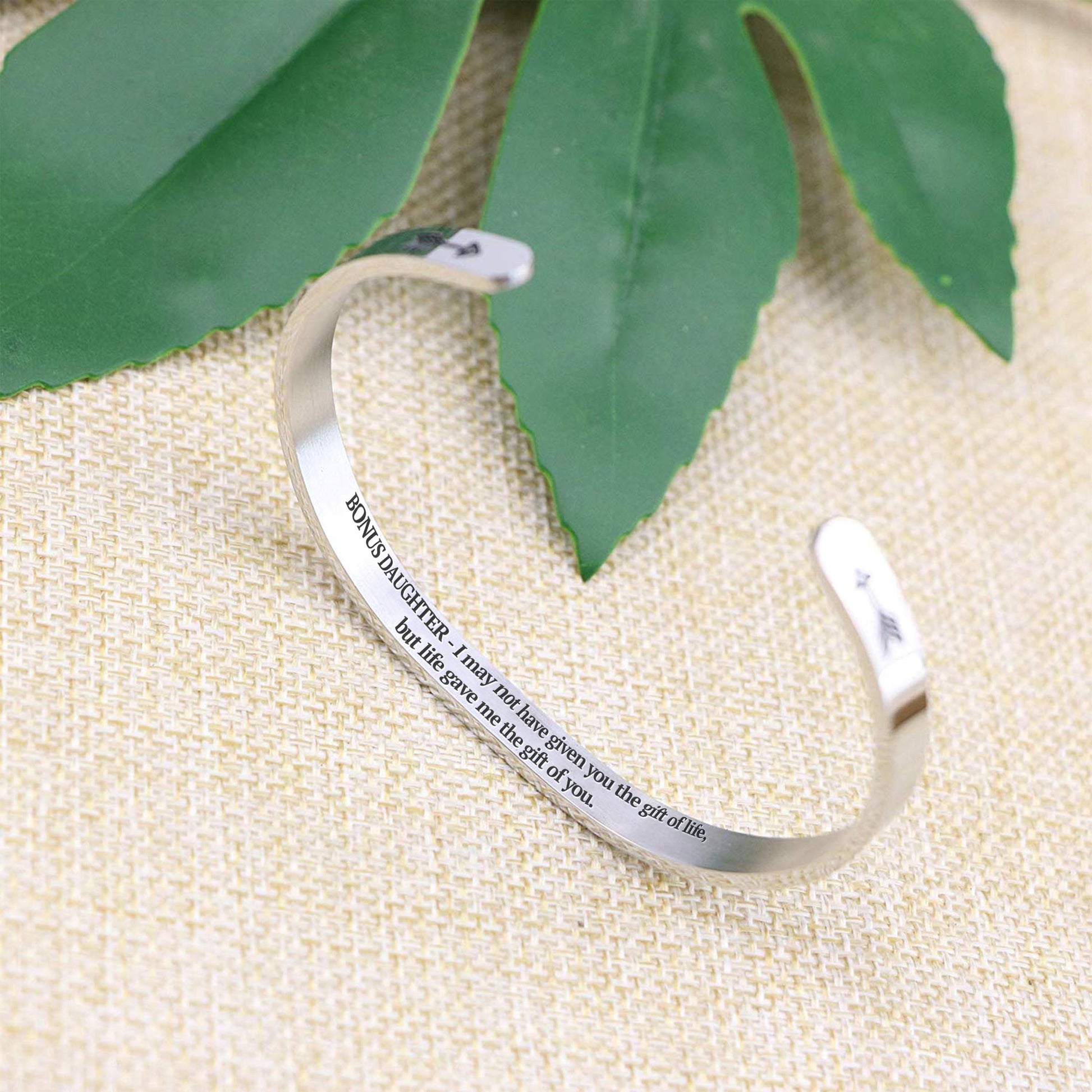 I may not have given you the gift of life but life gave me the gift of you bracelet with silver plating standing on a burlap surface with a leafy background